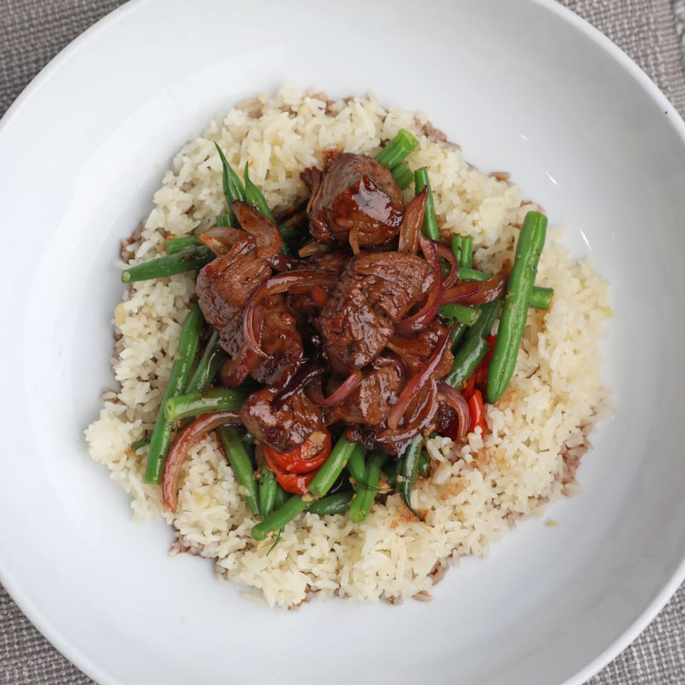 AnQi Bistro's Asian-fusion dish with beef, green beans, onions, and tomatoes over rice.