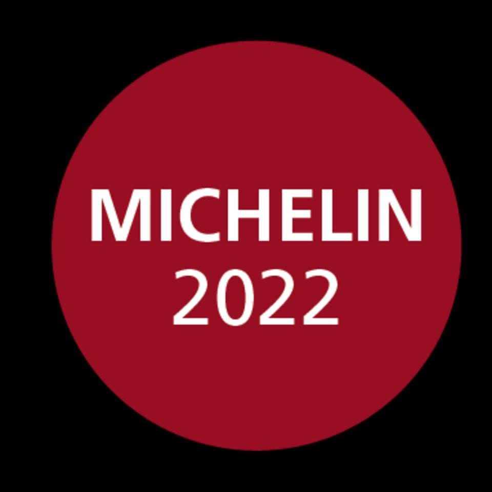 Red circular logo with white text: MICHELIN 2022, on a black background.