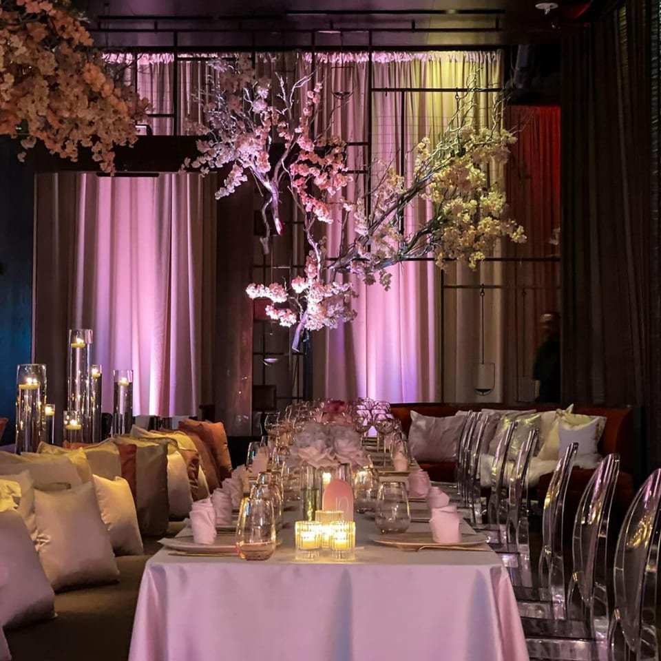 AnQi Bistro's elegant dining room with a long table set with candles and cherry blossom decor.